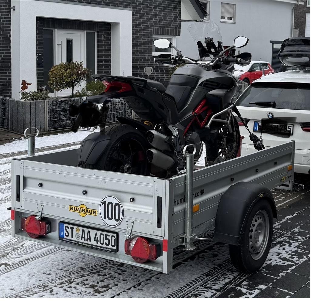 Schwarzes Motorrad von hinten auf Humbaur Anhänger